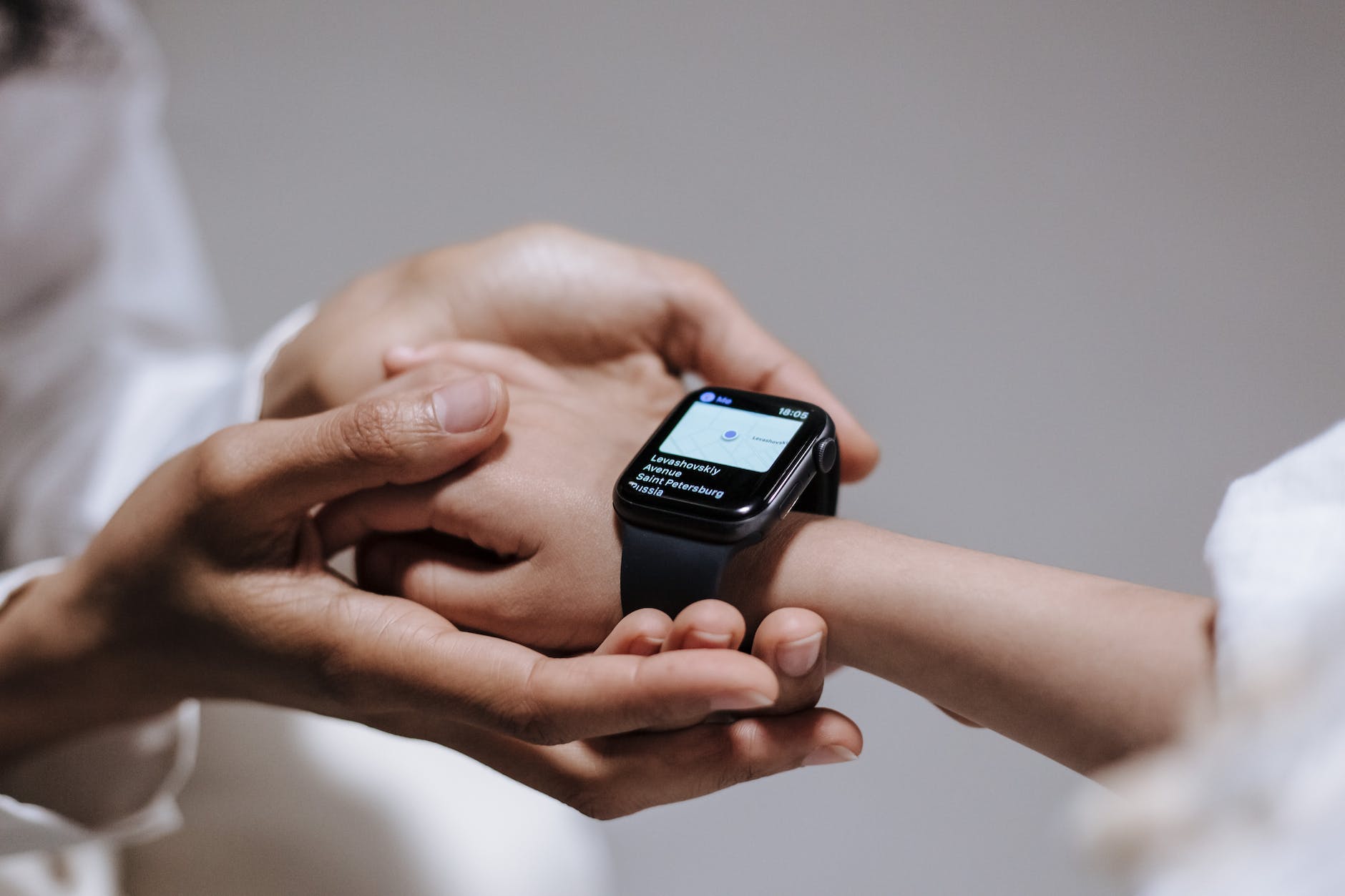 close up view of hand holding kid hand with smartwatch